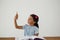 Young girl holding her pencil against white background