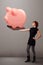 Young girl holding a huge savings piggy bank