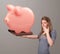 Young girl holding a huge savings piggy bank