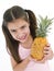 Young girl holding pineapple