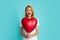 Young girl holding red air balloons. Valentines day. Isolated on blue background. Amazed woman in love. Excited
