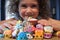 Young girl holding Shopkins a range of tiny collectable toys manufactured by Moose Toys