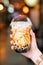 Young girl is holding and showing a cup of brown sugar flavored tapioca pearl bubble milk tea in night market of Taiwan background