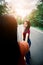 Young girl holding sister hand while leading her on road outdoor. Travel on countryside concept