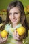 Young girl holding two lemons in greengrocery