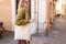 Young Girl holding white cotton tote bag on old town background. Mockup and zero waste concept. Eco Nature Friendly