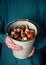 Young girl holds a full enamel bucket with spring flowers tulip varieties bulbs ready for planting.