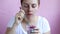 Young girl holds a glass with granola with natural yogurt, fresh raspberries, honey and eats her breakfast.