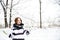 Young girl holds snowballs in winter landscape