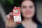 Young girl holds Tic-tac hard mints pack with coca-cola taste. Tic Tac is a brand of small hard mints, produced by Ferrero