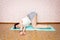 A young girl at home against the wall doing a fitness exercise hands in the lock sitting