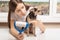 Young girl at home scolding a dog for wool, shows on a roller for cleaning