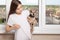 Young girl at home shows wool on clothes, holds a small dog in her arms