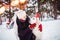 Young girl hugs dog with decorative deer horns Christmas labrador retriever in winter forest