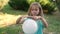 Young girl imitates wizard waving her hands over the white sphere