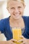 Young girl indoors drinking orange juice