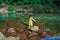 Young girl isolated standing in pristine clear waterfall water at morning in forests