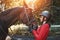 A young girl jockey talking to her horse. She loves the animals and joyfully spends her time in their environment
