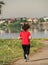 Young girl jogging in the morning. Woman working out on Lacul Morii or Windmill lake in Bucharest