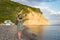 A young girl on a journey takes pictures on a mobile phone landscape, against the background of mountains and the sea