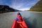 Young girl kayaking down a dart river of New Zealand