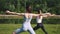 Young girl keeping body in tone, training outdoors on warm early sunny morning in the park. Stretching and yoga