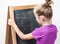 Young girl learning to write letters on blackboard