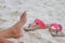 Young girl legs and flip-flop on the sand beach