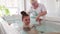 A young girl lies on her back in the bathroom and receives a relaxing massage.