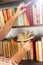 Young girl in light-colored dress choosing books in the vintage university library, reading book and relaxing.