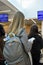 Young girl with long blond hair and with large travel backpack at airport