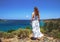 Young girl in a long dress on the beach looks into the distance, the concept of romance, relaxation, waiting