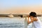 Young girl looking through a coin operated binoculars on luxury yacht port in Nesebar, Bulgaria