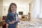 Young Girl Looking At Family Photographs On Table At Home