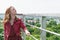 A young girl looks at the city from a panoramic balcony