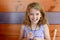 Young girl luaghing and smiling at the camera in a wooden restaurant booth