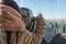 Young Girl Lurking Through Tourist Binoculars Reflecting New York City.Young girl peeking through tourist binoculars with reflecti