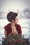 A young girl in a lush Marsala dress with a large bouquet of red anemones on the background of a winter landscape