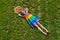 Young girl on lying on freshly mowed lawn