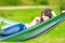 Young girl lying on a hammock with cell phone