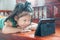 Young Girl lying on wooden stool and Learning online course on Wireless Digital Tablet