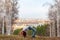 A young girl makes an acrobatic bridge on nature against the backdrop of a blurred city and forest.