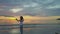 Young Girl Makes Selfie against Sunrise above Ocean Skyline