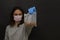 A young girl in a medical disposable mask and blue latex gloves shows a bag of buckwheat. Arm extended forward. Essential goods.