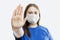 A young girl in a medical mask extended her hand forward: stop. Precautions during the coronavirus pandemic. Close-up. Defocus