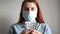 Young girl in a medical mask holds pills. Sick patient holds blister with pills