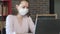 Young girl in medical mask is working on laptop. Home office. Safety work home.