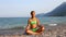 Young girl meditating on the beach