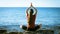 Young girl meditating on the coast in yoga pose