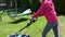 Young girl mows a lawn with an electric lawn mower